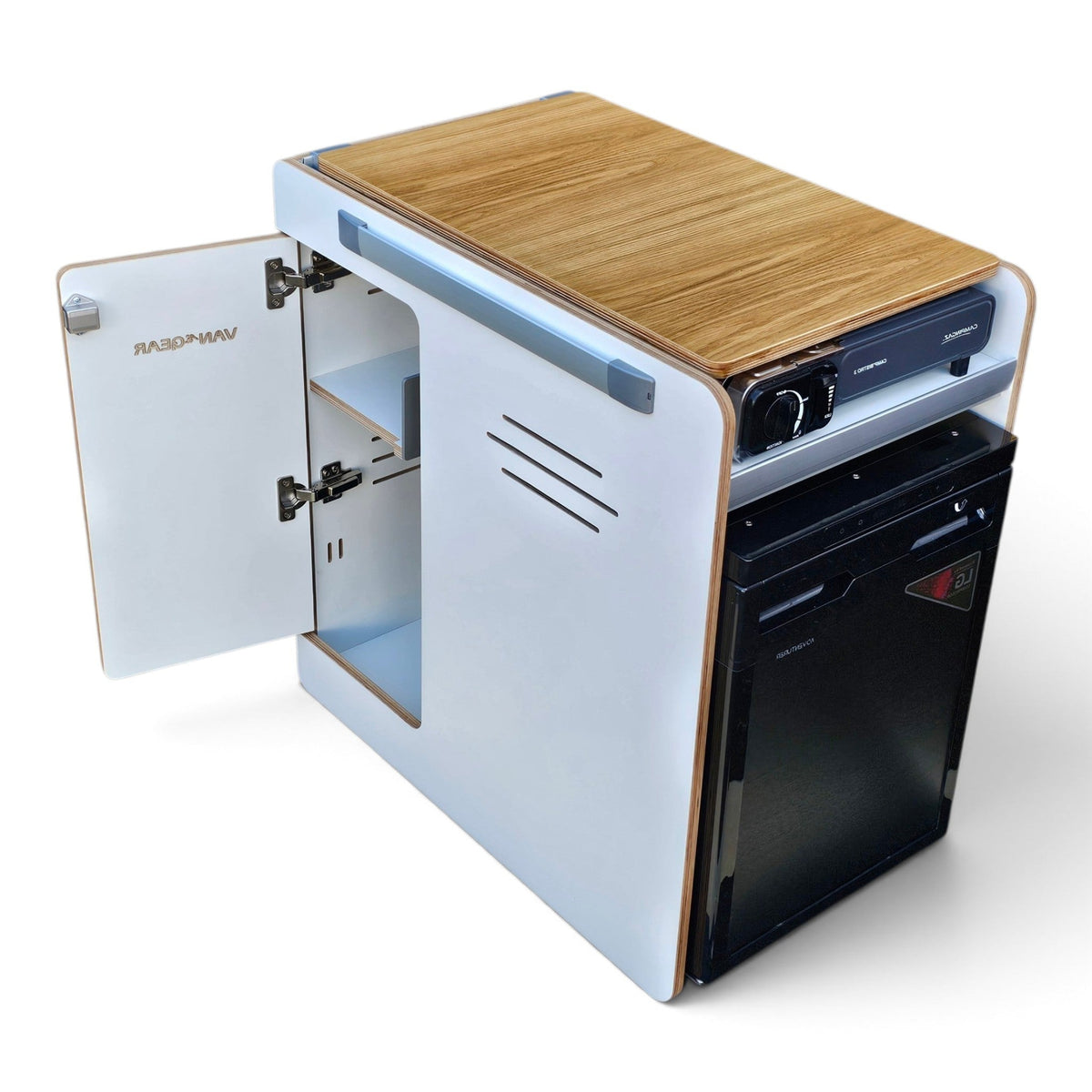 A compact RV kitchen cabinet with a wood-grain top, white exterior panels, an open side door showing storage shelves, and a built-in black refrigerator. The brand name 'VAN WEAR' is visible on the door.