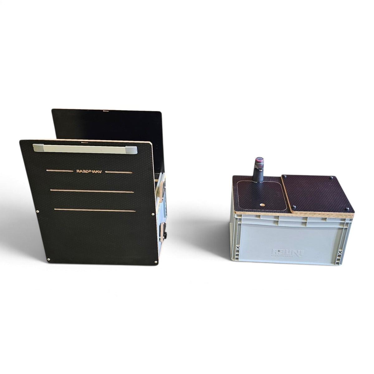 Two electronic device units on a white studio background, one shown from the side in a light gray crate with dark top panels, and the other shown from the back in a black rectangular housing with gold-toned trim.