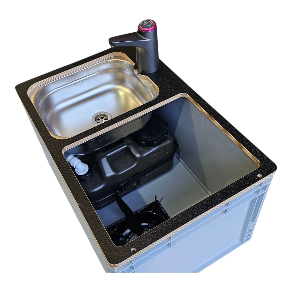 A compact dual-basin sink unit with a stainless steel upper basin, black lower basin, dark textured countertop, integrated faucet, and visible black plumbing components inside, isolated on a white background.